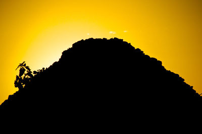 Low angle view of silhouette yellow against sky during sunset