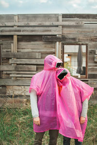 Rear view of man with pink umbrella against sky