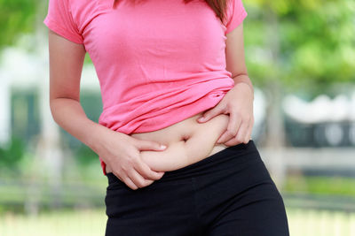 Midsection of young woman holding tummy