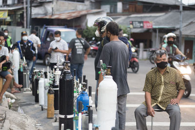 Rear view of people walking on street in city