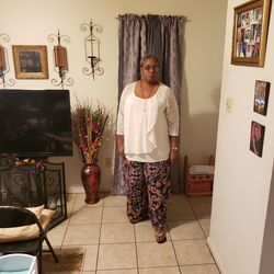 Portrait of smiling woman standing against wall at home