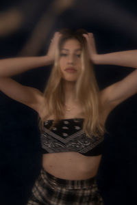 Young woman standing against black background