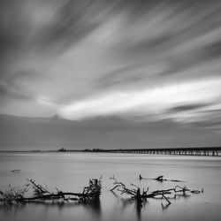 Scenic view of calm sea against cloudy sky