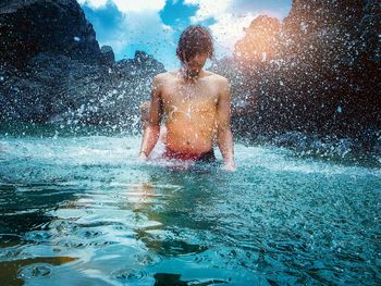 Full length of shirtless man in swimming pool