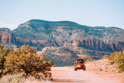 Scenic view of road by mountains against sky