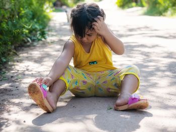 Rear view of girl sitting outdoors