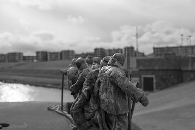 Rear view of figurine against sky in city