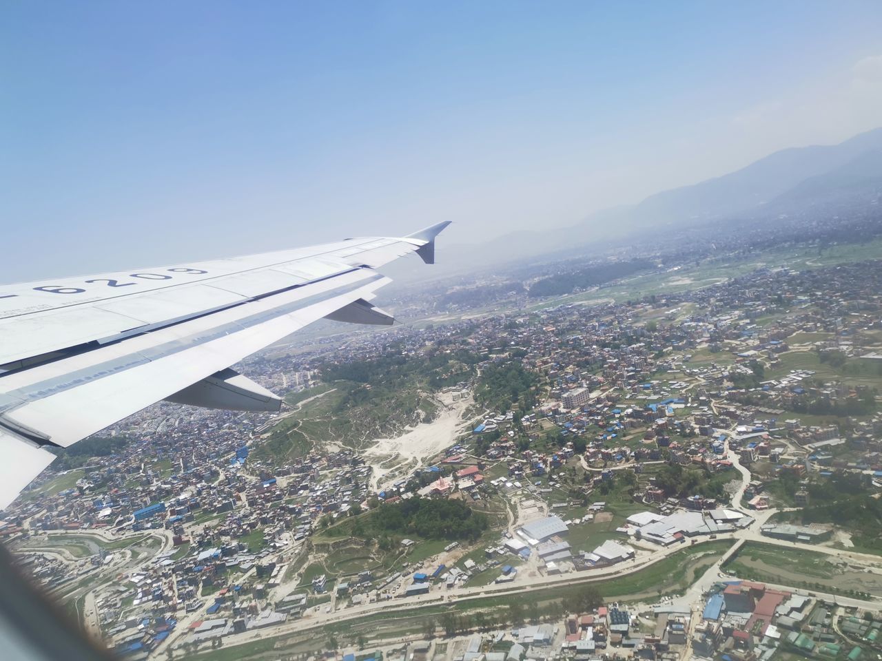 AERIAL VIEW OF AIRPLANE FLYING IN CITY