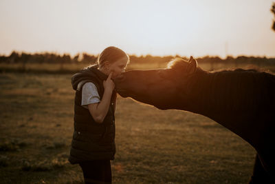 Side view of couple on field during sunset