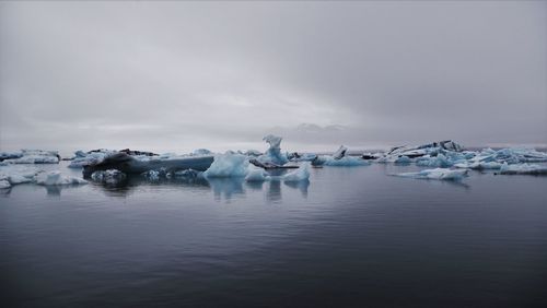Scenic view of jokulsarlon with iceberg against cloudy sky