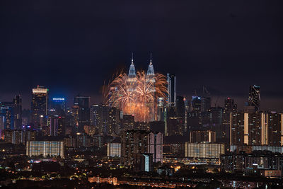 Illuminated cityscape against sky at night