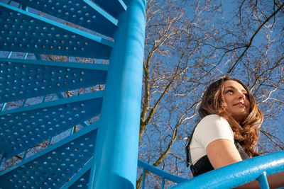 Low angle view of woman against blue sky