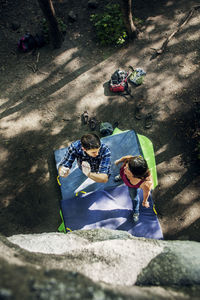 Overhead view of couple preparing for rock climbing at forest