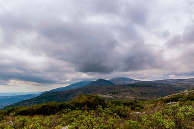 Scenic view of mountains against cloudy sky