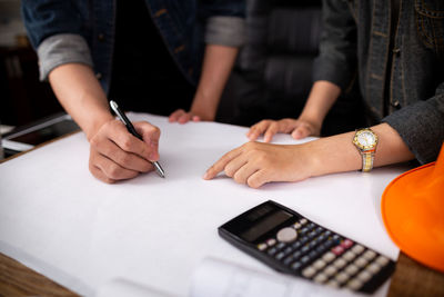 Midsection of woman using mobile phone on table
