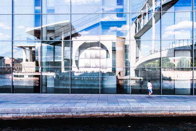 Reflection of bridge and canal on glass building
