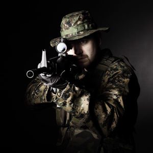 Midsection of man wearing mask against black background