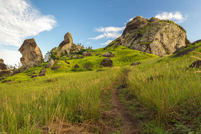 Scenic view of rocks on field against sky