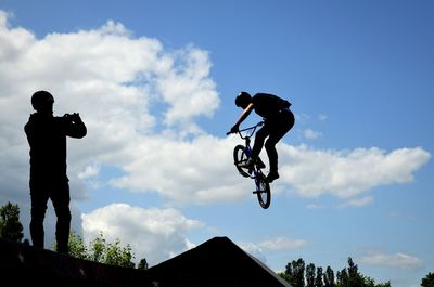 Low angle view of man jumping against clear sky