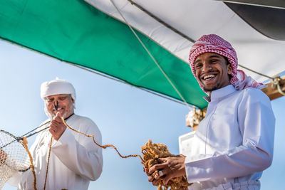 Low angle view of a man holding umbrella