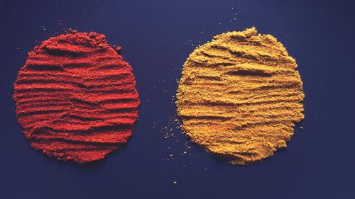 Close-up of paprika and cumin on blue background