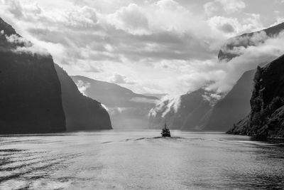 Scenic view of fjord and mountains against sky