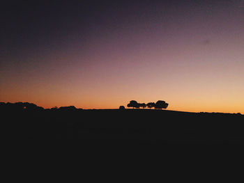 Silhouette landscape against clear sky during sunset
