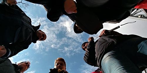 Low angle view of people walking against sky