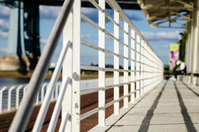 Metal railing on footpath against sky