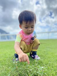 Portrait of cute boy playing with grass