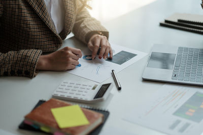 Midsection of business colleagues working on table