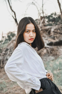 Portrait of beautiful young woman standing on land