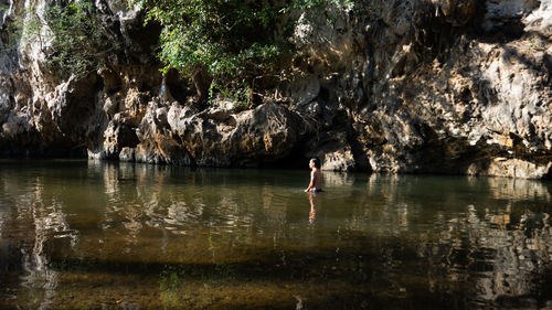 Woman standing on rock by lake