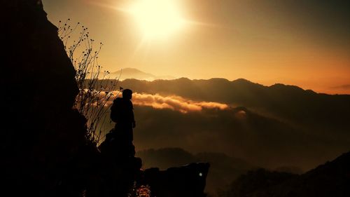 Silhouette people standing on mountain against sky during sunset