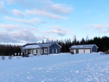 House on field against sky during winter