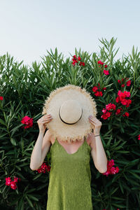 Midsection of person holding red flowering plant