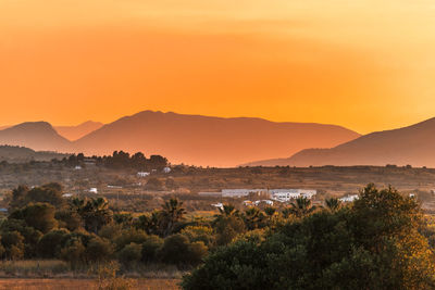 Scenic view of landscape against orange sky