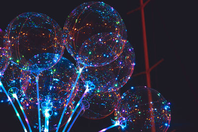 Low angle view of illuminated balloons at night