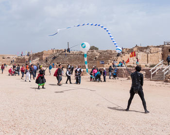 People at beach against sky