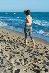 Full length rear view of woman on beach