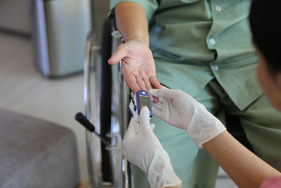 Midsection of doctor examining patient in hospital