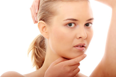 Close-up portrait of young woman against white background