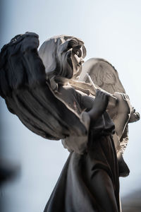 Low angle view of angel statue against sky