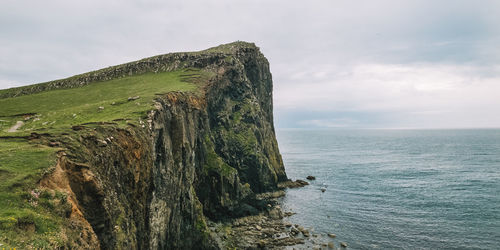 Scenic view of old man of storr against cloudy sky