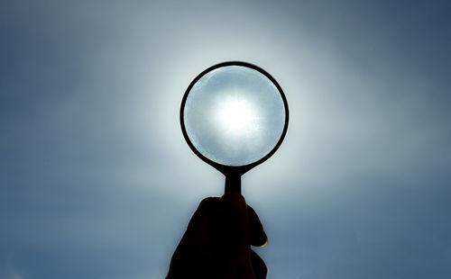 Hand with magnifying glass looking at the sun. magnifying glass.