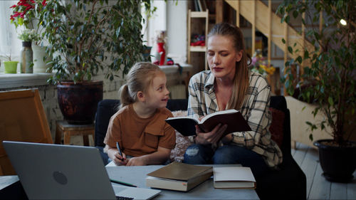 Mother teaching daughter at home