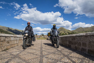 Motorbikes driving over a bridge of the urubamba river, peru