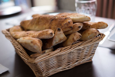 Close-up of baked breads in basket on table