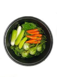 High angle view of vegetables in bowl against white background