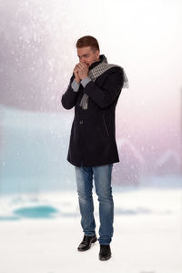 Full length of young man standing in snow